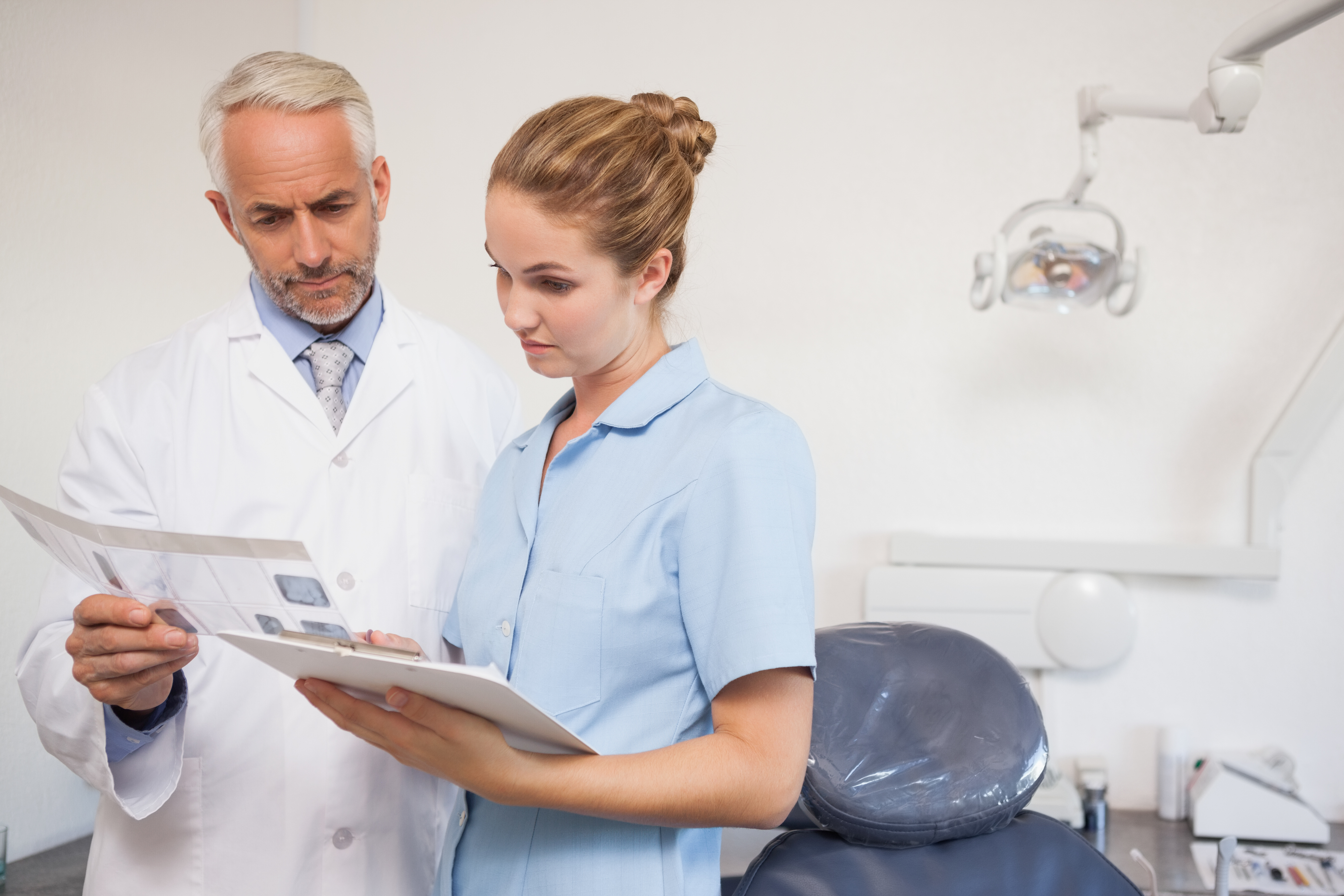 shutterstock_Dentist and assistant studying x-rays at the dental clinic.jpg